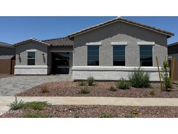 Charming single-story home showcasing a well-manicured front yard with desert landscaping and a neutral-toned facade at 16494 W Creedance Blvd, Surprise, AZ 85387