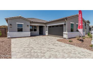 Charming home exterior with a paver driveway, a two-car garage, and desert landscaping at 16494 W Creedance Blvd, Surprise, AZ 85387