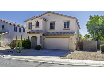 Beige two-story home featuring a two-car garage, tile roof and desert landscaping in front at 20200 N Donithan Way, Maricopa, AZ 85138