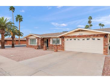 Charming single story brick home with a manicured front yard, desert landscaping, and an attached two car garage at 4306 E Dragoon Cir, Mesa, AZ 85206
