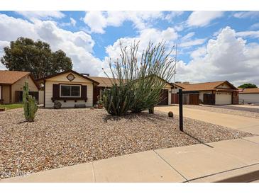 Charming single-story home with desert landscaping and a spacious driveway at 6313 W Paradise Ln, Glendale, AZ 85306