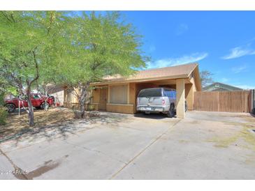 Cozy single-story home with a covered parking area and mature trees in a residential neighborhood at 7038 W Fillmore St, Phoenix, AZ 85043