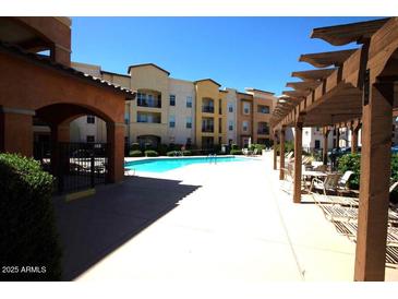 Beautiful community pool and pergola in a multi-Gathering home complex with seating areas at 14575 W Mountain View Blvd # 11212, Surprise, AZ 85374