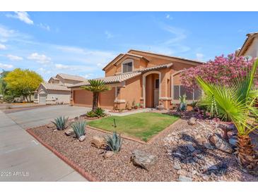 Charming two-story home with beautifully landscaped front yard, desert plants, and a three-car garage at 16040 W Grant St, Goodyear, AZ 85338