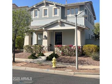 Charming two-story home featuring stone accents, covered porch, landscaped yard, and neutral gray siding at 21134 W Green St, Buckeye, AZ 85396