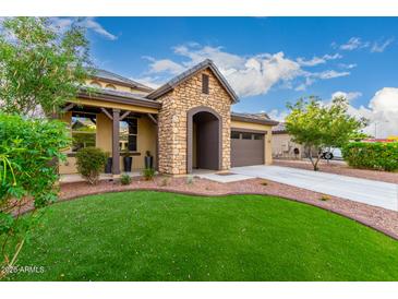 Charming single-Gathering home featuring a stone archway entrance, well-kept lawn, and a two-car garage at 21972 N 97Th Gln, Peoria, AZ 85383