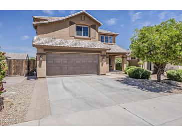 Charming two-story home with a desert landscape, a tile roof and a spacious driveway leading to the garage at 2408 W Saint Kateri Dr, Phoenix, AZ 85041