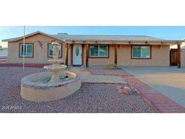 Single-story home featuring desert landscaping and a charming water fountain feature at 4132 E Sweetwater Ave, Phoenix, AZ 85032