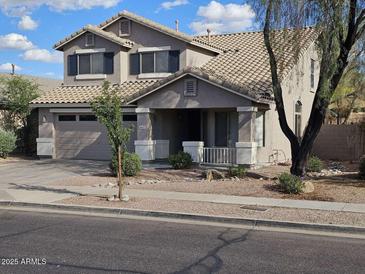 Two-story home featuring a neutral color scheme, desert landscaping, and attached two car garage at 4613 W Fawn Dr, Laveen, AZ 85339