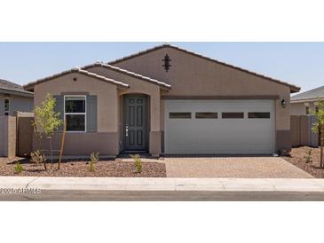 Charming single-story home with a gray door, two-car garage, and low-maintenance front yard at 5537 S 246Th Ave, Buckeye, AZ 85326