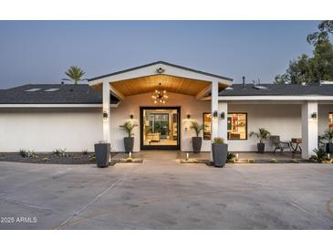 Elegant home exterior featuring a grand entrance with manicured landscaping and stylish lighting at 7100 N 47Th St, Paradise Valley, AZ 85253