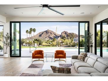 Bright, airy living room with floor-to-ceiling windows offering stunning views of the pool and surrounding landscape at 7100 N 47Th St, Paradise Valley, AZ 85253
