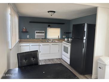 Eat-in kitchen area with modern laminate flooring and white cabinetry at 9913 E Main St # 40, Mesa, AZ 85207