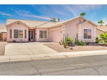 Charming single-story home featuring a light pink facade, desert landscaping, and a spacious driveway at 1633 E Jasmine St, Casa Grande, AZ 85122