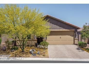 Charming home featuring well-manicured landscaping, a paver driveway, and a welcoming two-car garage at 16500 W Caldwell St, Goodyear, AZ 85338