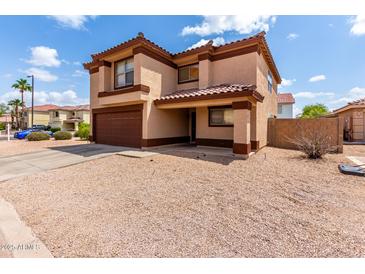 Two-story home featuring a brown-tone stucco exterior, a two-car garage, and a low-maintenance front yard at 2893 E Cherry Hills Dr, Chandler, AZ 85249