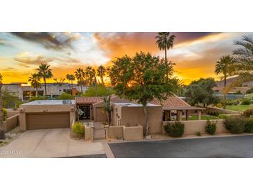 Stunning home featuring lush desert landscaping, a two-car garage, and a charming front gate at 4450 E Camelback Rd # 4, Phoenix, AZ 85018
