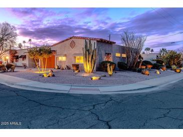 Charming single-story home with desert landscaping, lit for a stunning evening curb appeal at 7736 E Hazelwood St, Scottsdale, AZ 85251