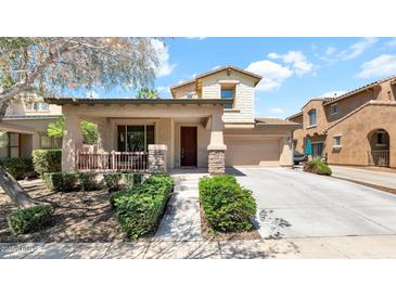 Charming two-story home featuring a covered porch, stone accents, and a well-manicured front yard at 13256 N 153Rd Ln, Surprise, AZ 85379