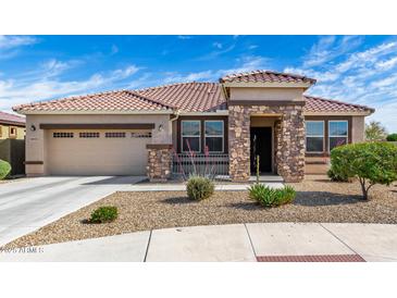 Charming single-story home with a tile roof and a stone-accented entrance, showcasing curb appeal at 18076 W Redwood Ln, Goodyear, AZ 85338