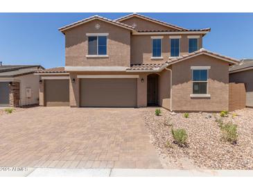 Attractive two-story home featuring a tile roof, three-car garage, and low-maintenance desert landscaping at 18189 W Hess St, Goodyear, AZ 85338