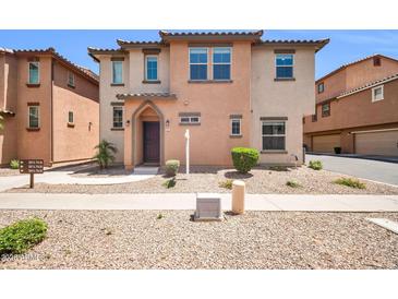 Inviting two-story home featuring desert landscaping and a charming front entrance at 2049 N 77Th Dr, Phoenix, AZ 85035