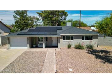 Charming home featuring solar panels, well-kept landscaping, and a welcoming front porch with a bench at 7320 E Pierce St, Scottsdale, AZ 85257
