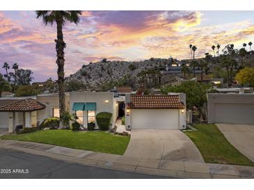 Charming single-story home with a tile roof, lush landscaping, and a well-manicured lawn in a serene setting at 7714 N 17Th Pl, Phoenix, AZ 85020