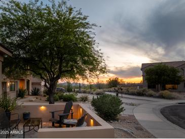 Inviting outdoor patio with desert landscaping, seating, and a beautiful sunset view at 10527 E Acacia Dr, Scottsdale, AZ 85255