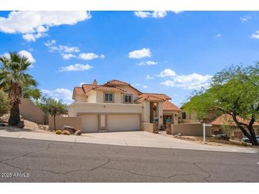 Beautiful two-story home featuring a three-car garage, tile roof, and well-manicured desert landscaping at 1221 E Claire Dr, Phoenix, AZ 85022