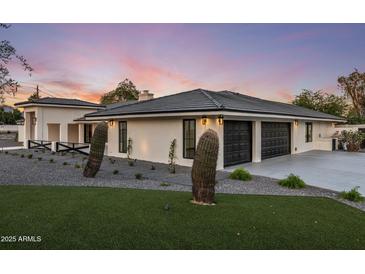 Stunning exterior featuring a modern design, desert landscaping, and a spacious three-car garage at 13365 N 74Th St, Scottsdale, AZ 85260