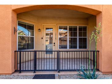 Inviting front porch with a black metal fence and tile flooring, perfect for enjoying the outdoors at 14575 W Mountain View Blvd # 12107, Surprise, AZ 85374