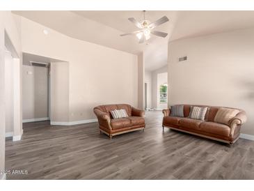 Spacious living room featuring modern flooring, neutral walls and comfortable leather seating at 14624 N 90Th Ln, Peoria, AZ 85381