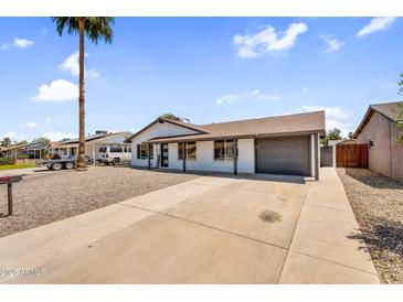 Charming single-story home featuring a low-maintenance front yard with a long driveway and attached garage at 14635 N 37Th Pl, Phoenix, AZ 85032
