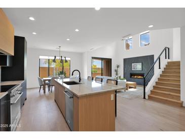 Open concept kitchen with stone countertops, stainless steel appliances, and an adjacent dining area leading into the living space at 19550 N Grayhawk Dr # 1039, Scottsdale, AZ 85255
