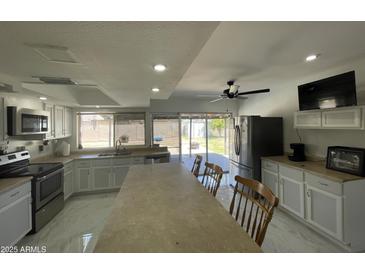 Bright, open kitchen with stainless steel appliances and a large island perfect for entertaining at 3738 W Danbury Dr, Glendale, AZ 85308
