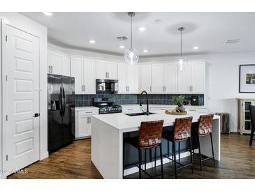 Modern kitchen features white cabinets, a large island, and stainless steel appliances at 4543 S Nebula --, Mesa, AZ 85212
