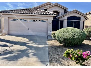 Charming home with a well-manicured front yard and a two-car garage featuring decorative windows at 6626 W Monona Dr, Glendale, AZ 85308