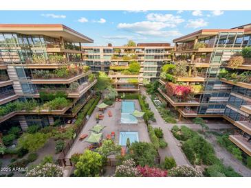 Stunning aerial view of luxurious condos with beautiful landscaping and a sparkling pool at 7121 E Rancho Vista Dr # 6001, Scottsdale, AZ 85251
