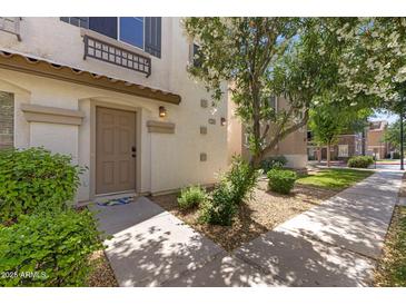 Charming condo entrance with a well-maintained door, beautiful flowering tree, and landscaped front yard at 753 N Port Dr, Gilbert, AZ 85233