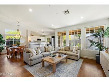 Bright living room featuring hardwood floors, recessed lighting, and large windows overlooking the backyard at 10239 E Salt Bush Dr, Scottsdale, AZ 85255