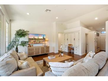 Comfortable living room with built-in features, hardwood flooring, neutral tones, and lots of natural light at 10239 E Salt Bush Dr, Scottsdale, AZ 85255