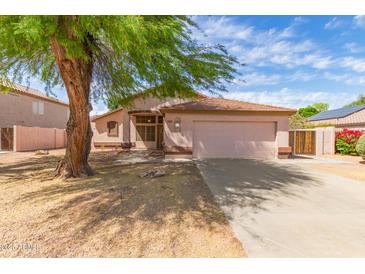 Charming single-story home with a well-maintained front yard and mature shade tree at 1028 W Chilton Ave, Gilbert, AZ 85233