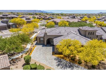 Stunning aerial view of a home with desert landscaping, tile roof, and a paver driveway in a vibrant community at 12325 S 179Th S Ave # 0, Goodyear, AZ 85338