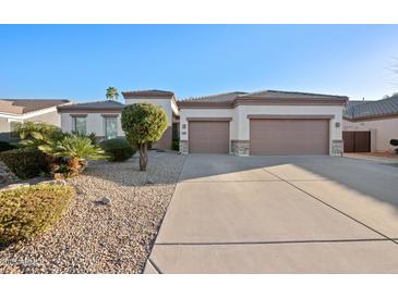 Charming single-story home features a spacious driveway, three-car garage, and desert landscaping at 3085 E Parkview Dr, Gilbert, AZ 85295