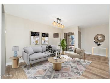 Bright living room featuring a modern couch, stylish decor, and a large window to let in natural light at 5221 N 24Th St # 103, Phoenix, AZ 85016