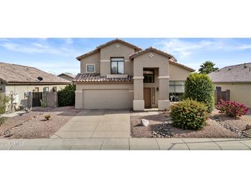 Two-story home featuring a neutral color palette, desert landscaping, a two-car garage and a tile roof at 5423 W Michigan Ave, Glendale, AZ 85308