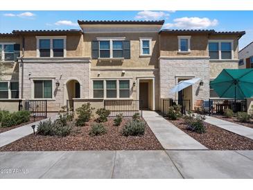 Charming townhome with beautiful stone accents and a well-manicured front yard at 1823 E Chelsea Ln # 106, Gilbert, AZ 85295