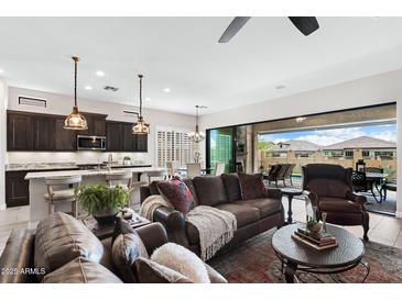 Inviting living room with a comfortable leather sofa and seamless indoor-outdoor flow to a private pool area at 2114 N Canelo Hls, Mesa, AZ 85207