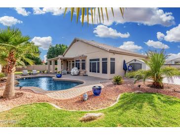 Serene backyard showcasing a private pool with a lush lawn and patio, perfect for outdoor entertaining at 22351 N 67Th Dr, Glendale, AZ 85310